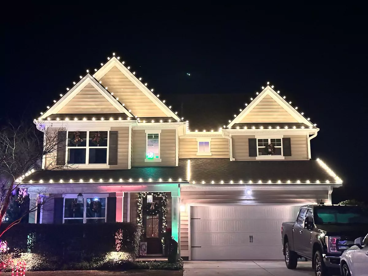 Two-story home with every gable and eave outlined in warm white